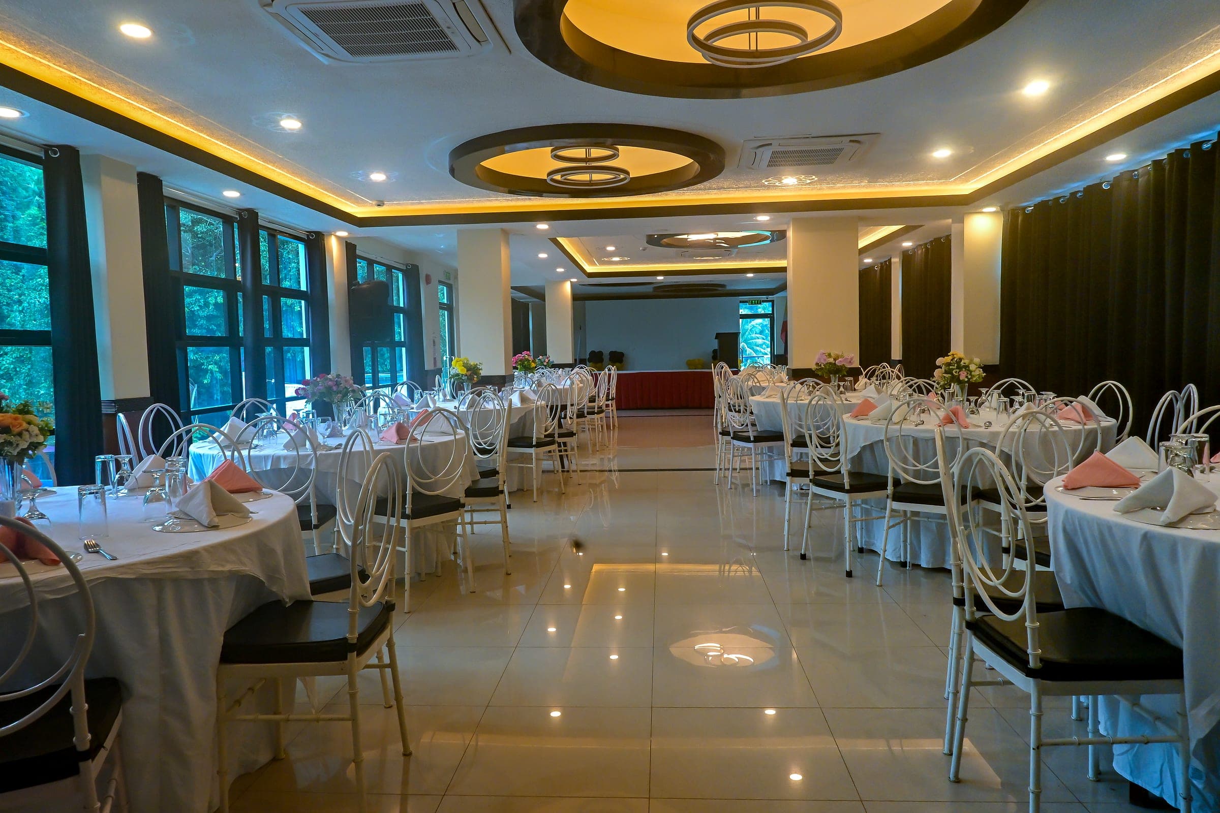 The function area set with round tables, with the raised stage at the far end